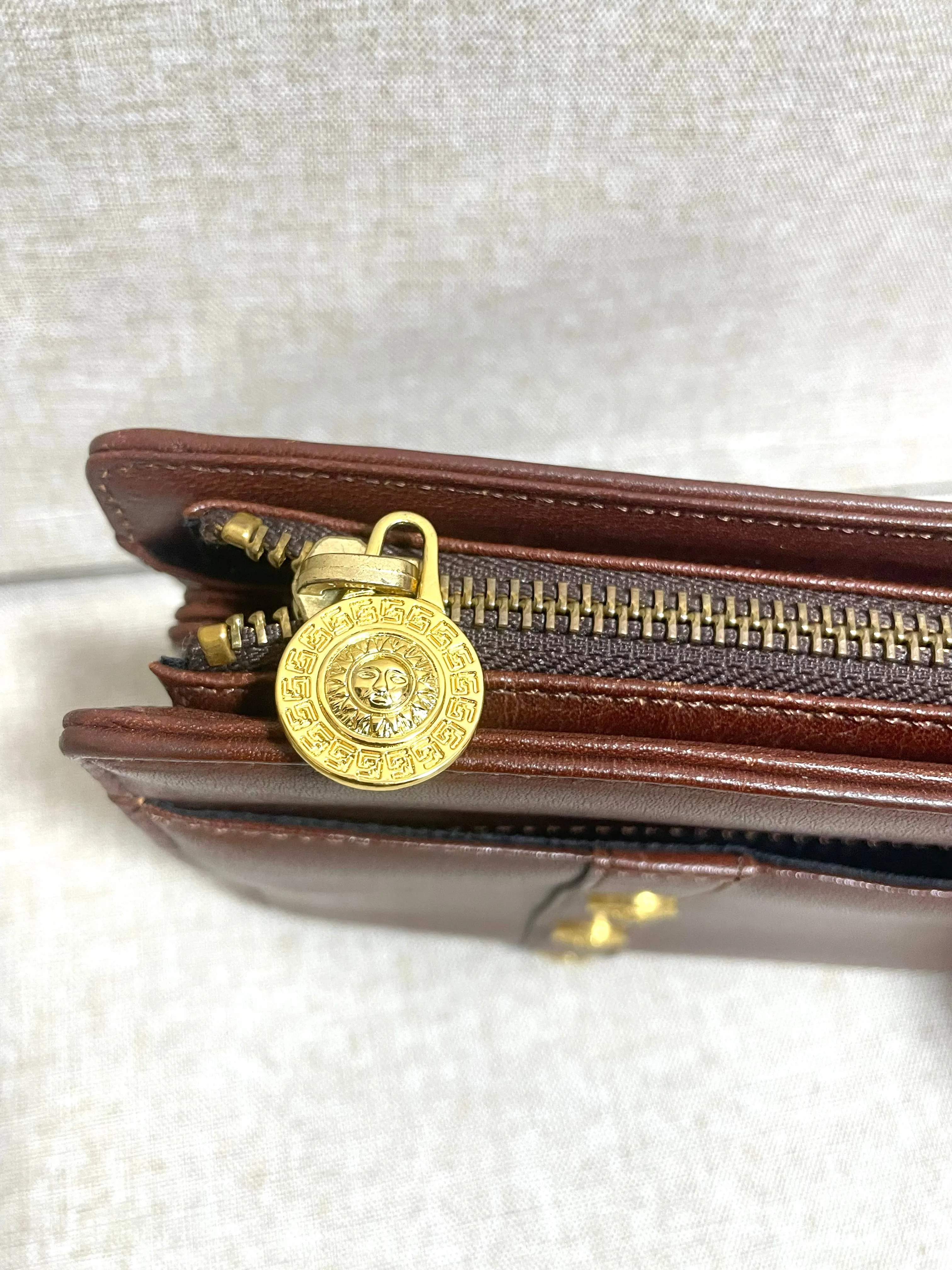Vintage Gianni Versace brown leather wristlet, purse clutch, case bag with its iconic golden sunburst charms. Unisex bag. 061027y1